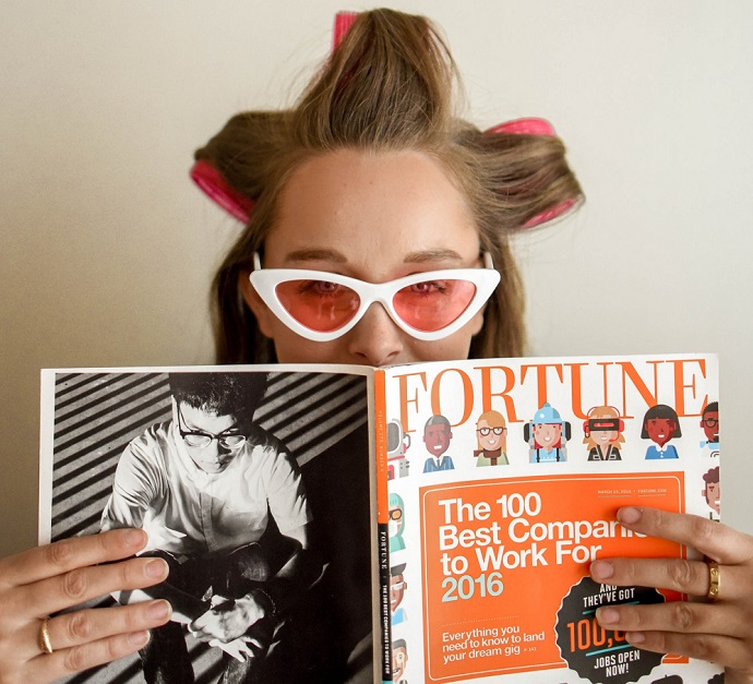 picture of a woman with a magazine in her hands, sunglasses and a hair curlers
