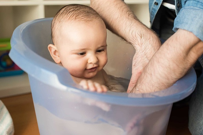 baby in bucket bath tub