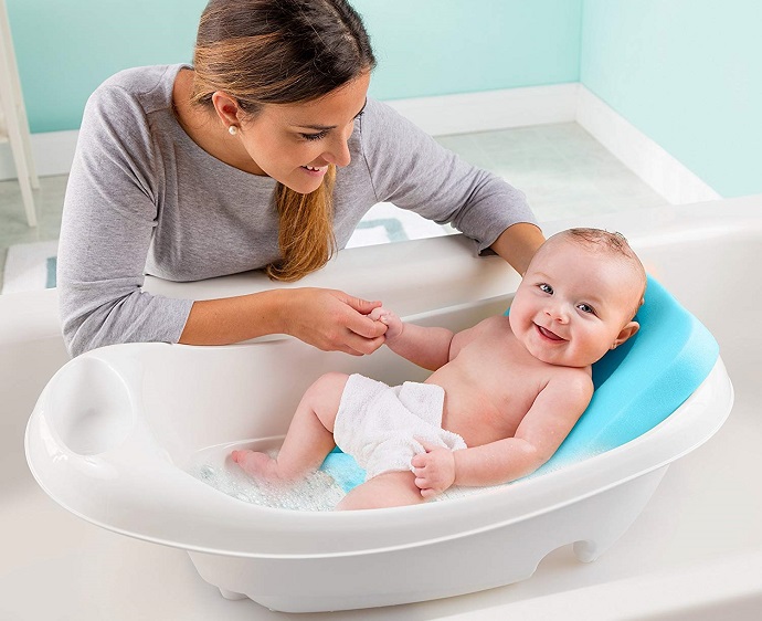 mom looking at baby in bath tub for babies